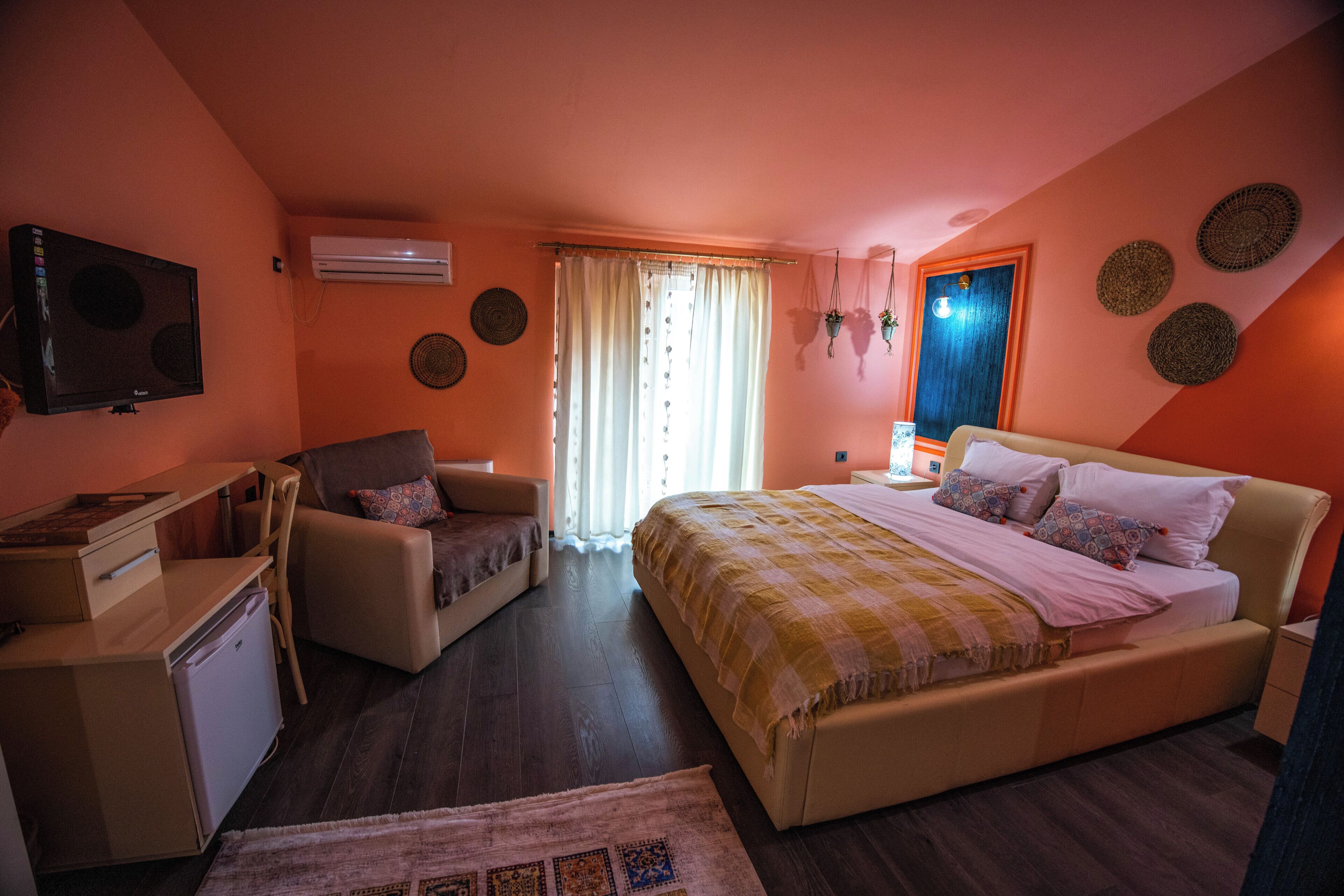 Une chambre à coucher comprenant un lit, un bureau, une chaise, une petite table et un téléviseur.