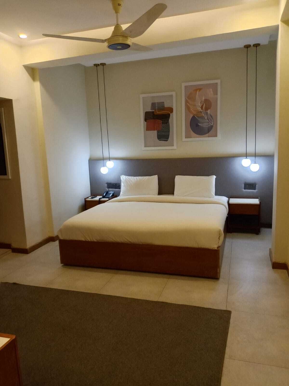 Una camera da letto moderna con un letto grande, comodini, una ventola a soffitto e luci a parete.
