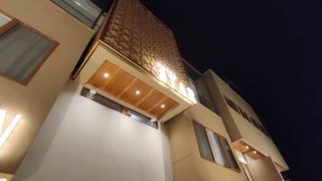 A modern building with a prominent sign, large windows, and a wooden ceiling design.