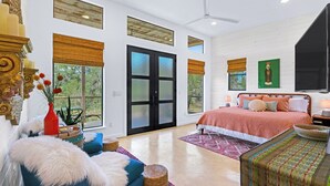 Ein geräumiges Schlafzimmer mit einem großen Bett, einer Sitzecke mit einem blauen Sofa und einem Essbereich mit Tisch und Stühlen.