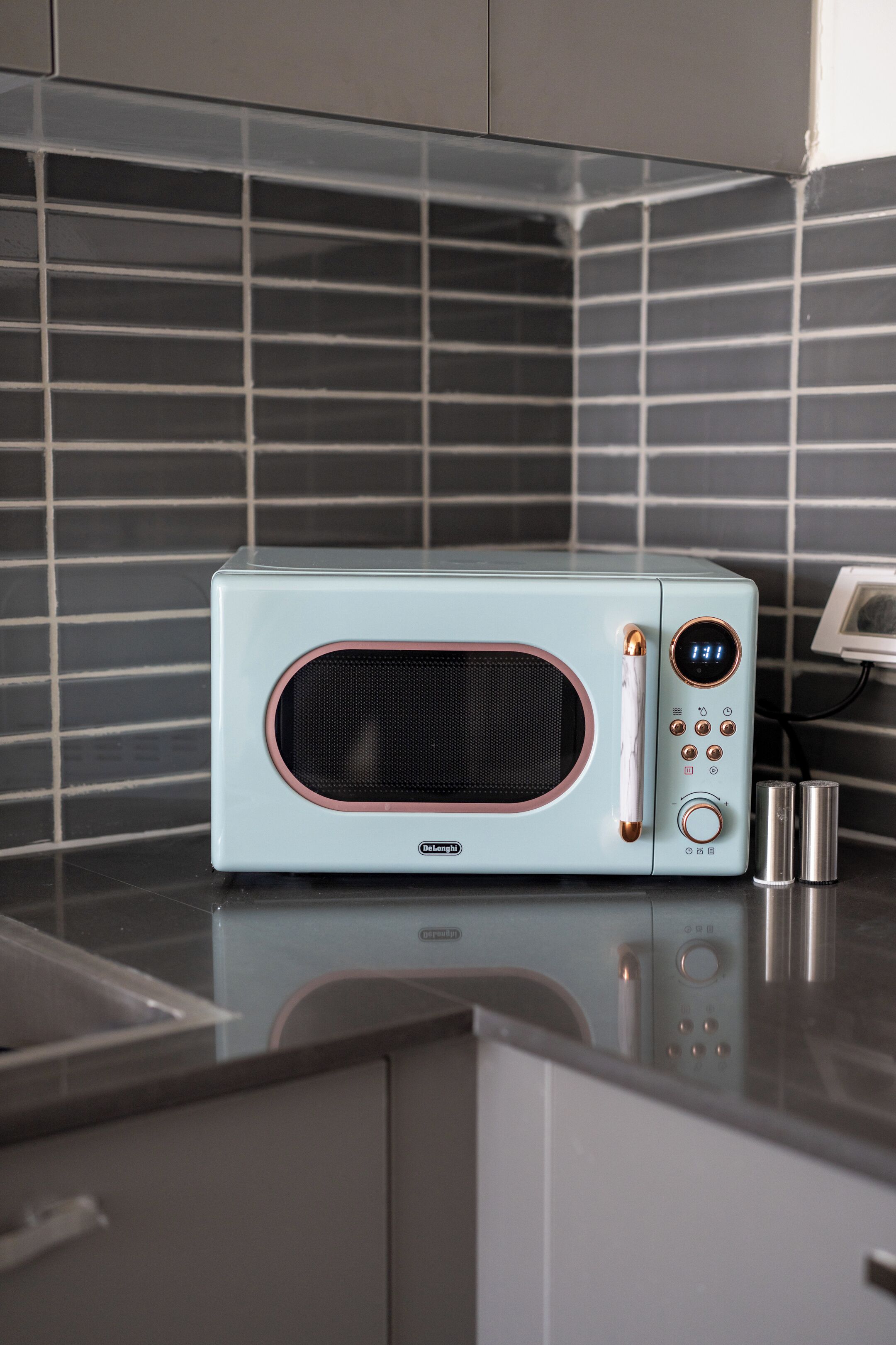 A microwave with a digital display and control buttons on a kitchen counter.