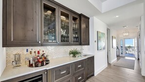 Une cuisine moderne avec des meubles en bois foncé, un plan de travail en marbre et une vue sur un balcon.