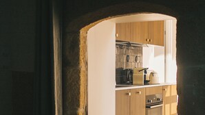 A kitchen with wooden cabinets, a stove, and a sink.