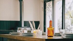 Una cocina moderna con una isla de madera, un ventanal grande y un jarrón con flores.