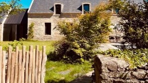A stone house with a sloped roof, a wooden fence, and a stone pathway leading to the entrance. - Maisons Bodenn - Le Penty (Plobannalec-Lesconil)