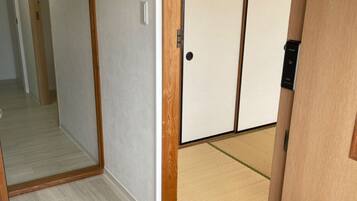 A room with a wooden floor, a sliding door, and a visible light switch.