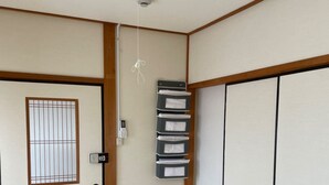 Une pièce de style japonais traditionnel, avec un sol recouvert de tatamis, des paravents shoji et une porte coulissante.
