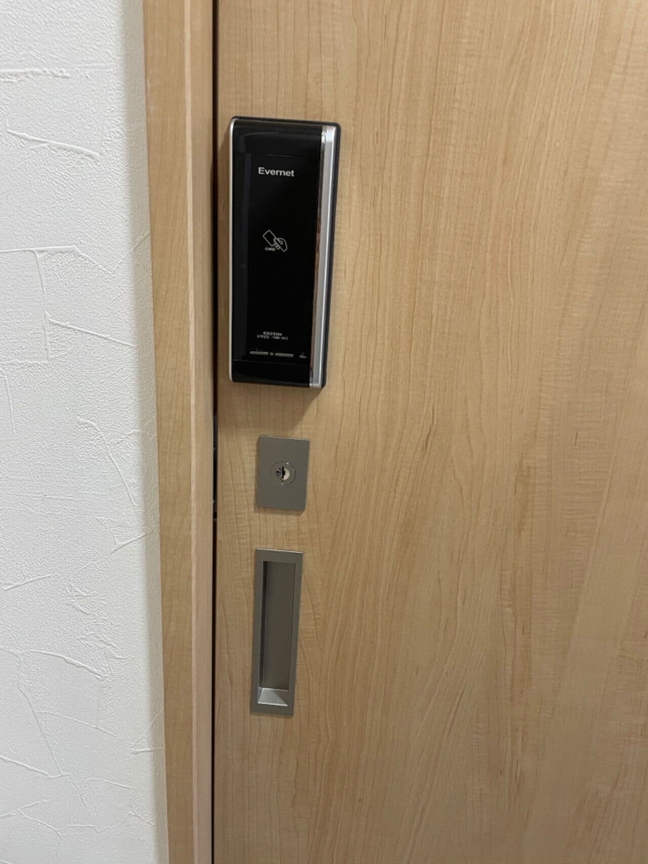 A modern door with a digital keypad lock and a keyhole, indicating a secure entry system.