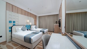 A hotel room with two beds, a desk, a large mirror, and a TV. - Sunway Tabuk Hotel (Tabuk)