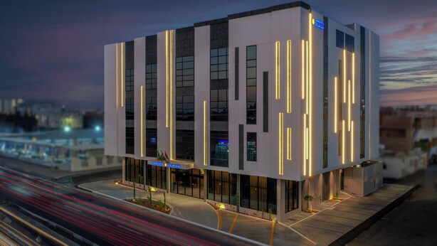 A modern hotel with a clean, geometric facade and illuminated vertical lines. - Sunway Tabuk Hotel (Tabuk)