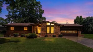 A two-story house with a brick facade, a garage, and a well-maintained lawn. - Becca's Place 3 Bedroom Home by RedAwning (Pigeon Forge)