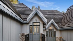 A house with a grey exterior, a stone foundation, and a tiled entrance area. - Summer 2026 Special - Amenities that include Pool, Steam Room, Sauna, Tennis, AC (sunriver)