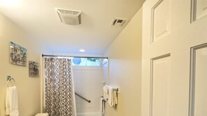 A bathroom with a toilet, sink, bathtub, and shower curtain. - Rent at PORCHSIDE PARADISE - Steps to Duval (Key West)