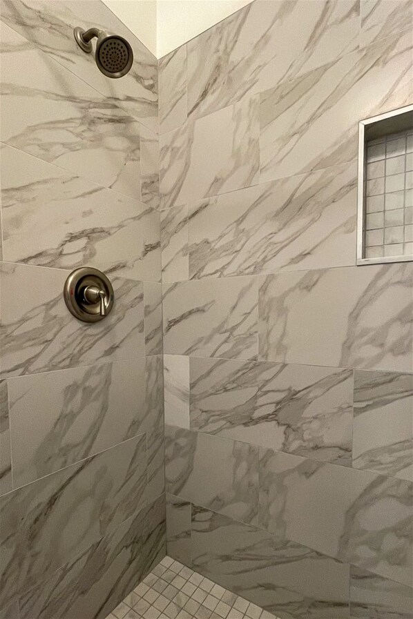 Ducha con cabezal de ducha de mano y llave de control de pared.
