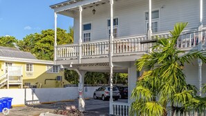 A white building with a balcony and a covered walkway. - LA CASA CUBANA @ Cuban Club Suites (Key West)