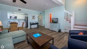 A spacious living area with a kitchen, a dining table, and a staircase. - LA CASA CUBANA @ Cuban Club Suites (Key West)
