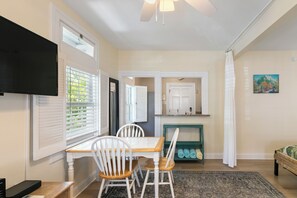 A dining area with a table, chairs, and a television mounted on the wall. - Hollinsed House Studio - Great Location!! (Key West)