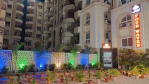 A hotel with a sign reading "FOUR WAVES" and a decorative fence with illuminated panels. - Hotel Four Waves (Puri)