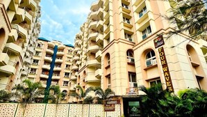 A multi-story hotel with a beige facade, balconies, and a reception area. - Hotel Four Waves (Puri)