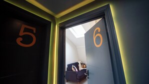 Un pasillo con puertas numeradas 5 y 6 que conduce a una habitación con cama y ventana.