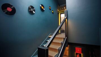 A staircase with a metal railing and a blue wall.
