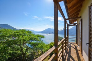 A wooden balcony with a view of a lake and mountains. - Costa Del Fuoco (Bellano)