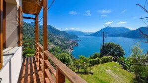 Un balcón de madera con vistas a un lago, con montañas al fondo.