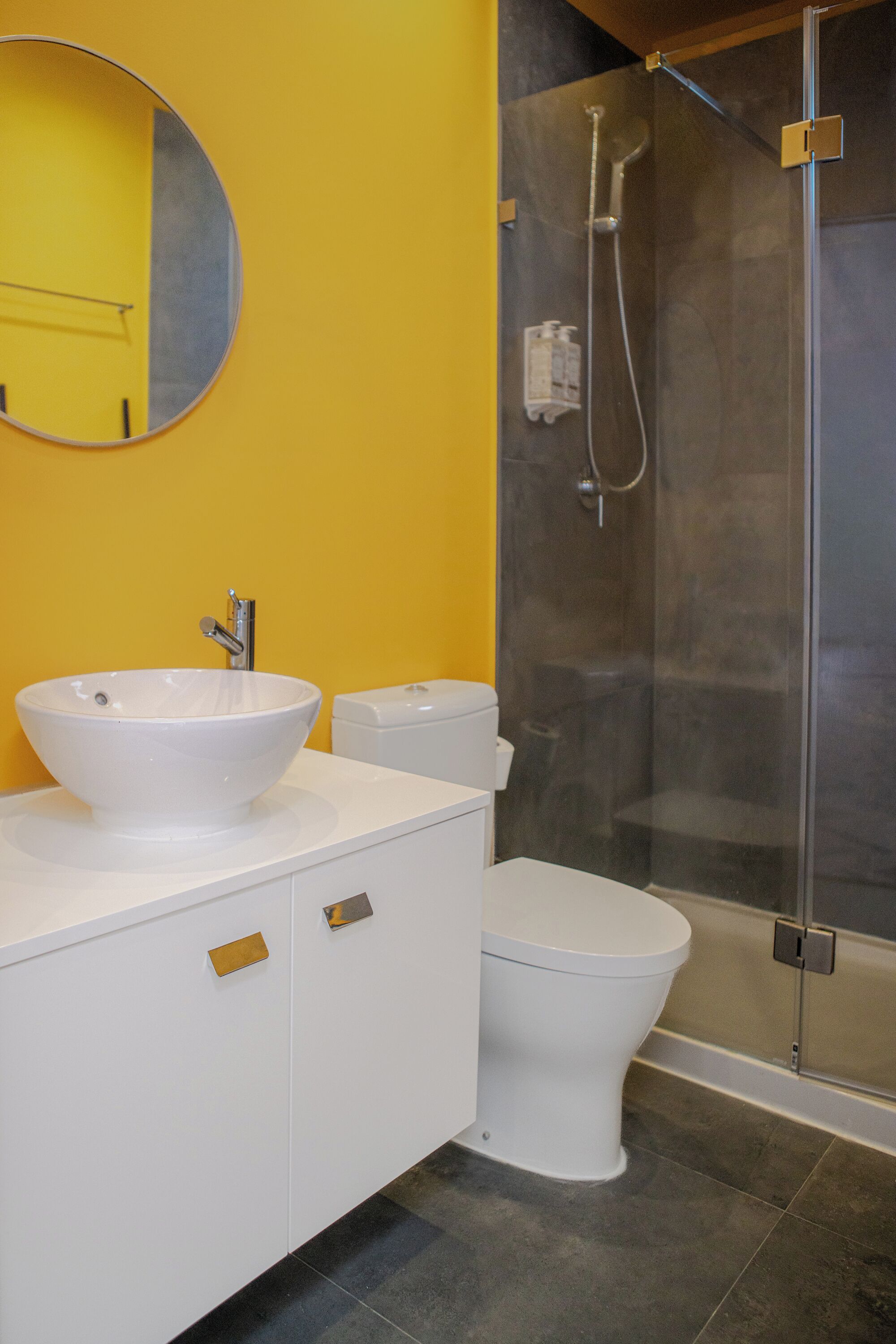 A bathroom with a white sink, toilet, and glass-enclosed shower.