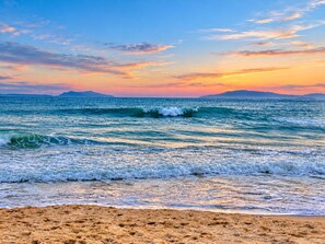 Platja amb onades i un atardec