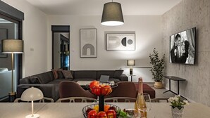 Una sala de estar moderna con sofá, mesa de comedor y televisor.