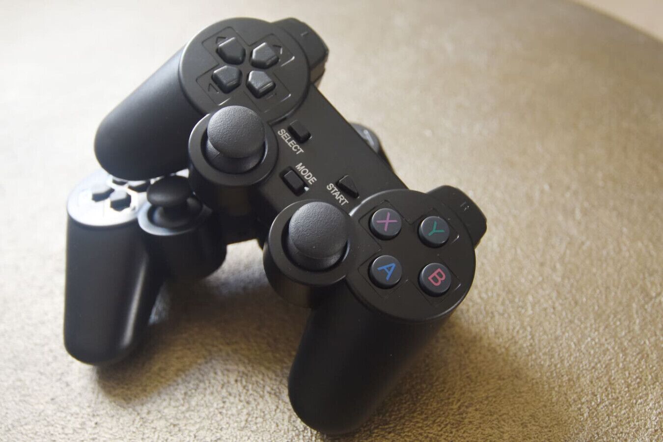 A black game controller with buttons and a directional pad.