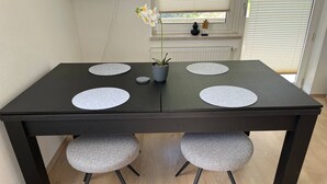 A rectangular dining table with two chairs, each with a round seat cushion. - Timber Suite - near Rußweiher (Eschenbach in der Oberpfalz)