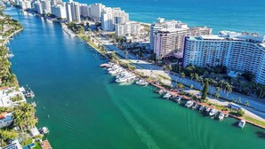 A coastal cityscape with a marina, high-rise buildings, and a clear view of the ocean. - Oceanfront 2BR at The Alexander · Pools + Beach (Miami)