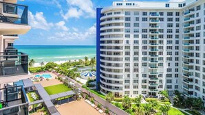 A high-rise hotel with multiple balconies, a pool area, and a beach view. - Oceanfront 2BR at The Alexander · Pools + Beach (Miami)