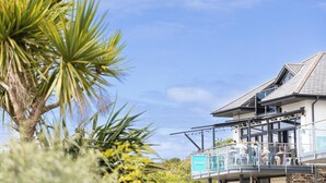 A beachfront hotel with a balcony area labeled "Upper Deck" and a sign for "The Beach House." - Beachfront apartment in Rock - Parking - Sea Views (Rock)