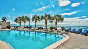 A pool area with clear blue water, palm trees, and a view of the ocean. - 3BR Harbor front + Panoramic Views + Pool & Beach Access | East Pass Towers (Destin)