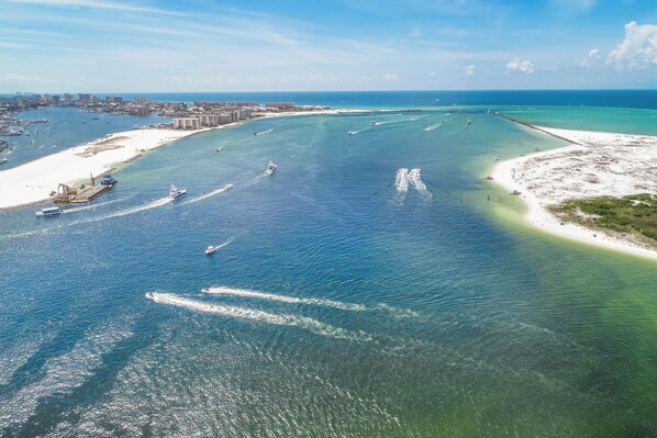 An aerial view of a coastal area with a marina, boats, and a beach. - 3BR Harbor front + Panoramic Views + Pool & Beach Access | East Pass Towers (Destin)