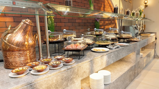 Ein Buffet mit verschiedenen Speisen und einem großen Kupfertopf.