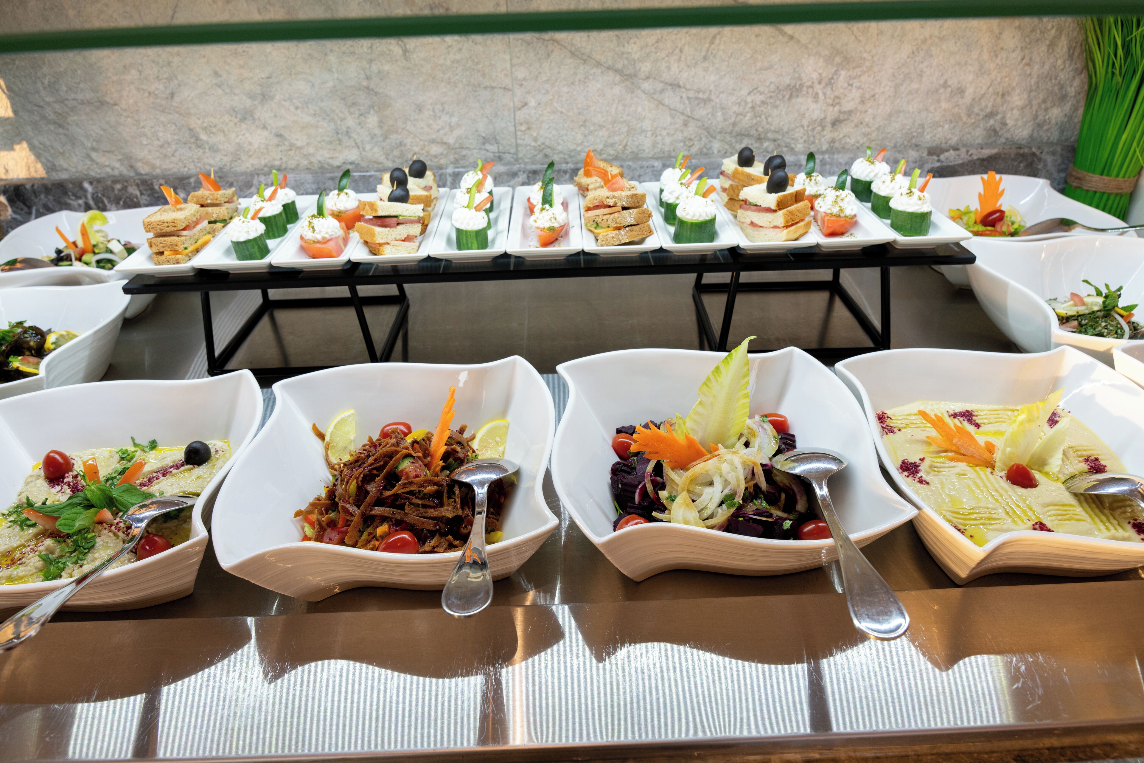 A buffet table with various dishes and a salad bar.