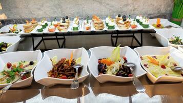 A buffet table with various dishes and a salad bar.