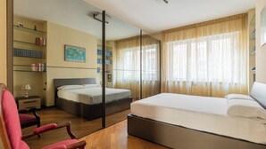 Un dormitorio con una cama grande, un escritorio, una silla, una estantería y un mapa en la pared.