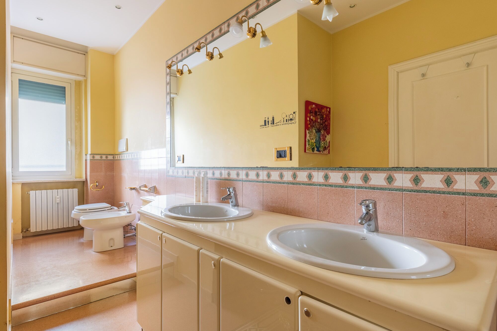 A bathroom with two sinks, a toilet, and a shower.