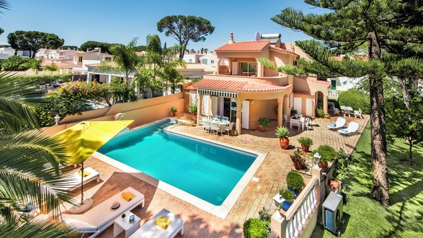 A poolside area with lounge chairs, a covered seating area, and a view of the surrounding neighborhood. - 4 Bedrooms Private Pool Close To All Amenities (Loulé)