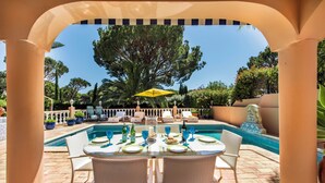 An outdoor dining area with a pool, white wicker chairs, and a yellow umbrella. - 4 Bedrooms Private Pool Close To All Amenities (Loulé)