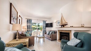 A living room with a sofa, armchairs, a fireplace, and a television. - 4 Bedrooms Private Pool Close To All Amenities (Loulé)