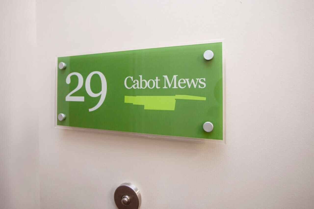 A green sign with the number 29 and the text "Cabot Mews" on a white wall.