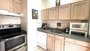 A kitchen with wooden cabinets, a stainless steel stove, a microwave, and a dishwasher. - NEW LISTING! Panoramic Views At Panorama! (Breckenridge)