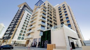 Un immeuble résidentiel de grande hauteur doté de nombreux balcons, de grandes fenêtres et d’une architecture moderne.