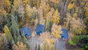 An aerial view of a forested area with three cabins. - Wilderness Escape 2 bedroom 1 bath 4 guests (Sterling)
