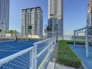 Residents can enjoy a game of soccer on the outdoor court, surrounded by a landscaped area with neatly trimmed bushes.
